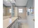 Bathroom featuring a single vanity with white cabinetry, a large mirror, and a shower-tub combo at 21902 King Henry Ave, Leesburg, FL 34748