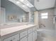 Bathroom featuring a single vanity with white cabinetry, a large mirror, and a shower-tub combo at 21902 King Henry Ave, Leesburg, FL 34748