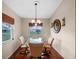 Elegant dining room with hardwood floors, stylish chandelier, and a scenic window view, ideal for gatherings at 21902 King Henry Ave, Leesburg, FL 34748