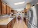 Traditional kitchen featuring wood cabinetry, stainless steel appliances, tile floors, and an adjacent dining area at 21902 King Henry Ave, Leesburg, FL 34748