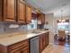 Traditional kitchen area featuring wood cabinetry, granite countertops, stainless appliances, and tile backsplash at 21902 King Henry Ave, Leesburg, FL 34748