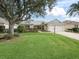 Charming single-story home with lush lawn, mature landscaping, and attached two-car garage at 2195 Marlboro St, The Villages, FL 32162