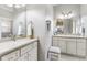 Dual vanity bathroom with neutral countertops, white cabinetry, and matching framed mirrors and lighting at 2197 Derringer Ave, The Villages, FL 32162