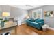 Bedroom showcases hardwood floors, a fan, and a comfortable blue love seat at 2197 Derringer Ave, The Villages, FL 32162