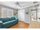 Bedroom showcases hardwood floors, a fan, and a comfortable blue love seat at 2197 Derringer Ave, The Villages, FL 32162
