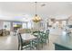Open-concept dining area featuring a stylish chandelier and seamlessly connected to the living room and kitchen at 2197 Derringer Ave, The Villages, FL 32162
