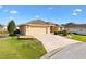 Exterior view showcasing the home's driveway and attached two-car garage at 2197 Derringer Ave, The Villages, FL 32162