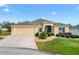 Home featuring a well-maintained lawn, manicured landscaping, and charming curb appeal at 2197 Derringer Ave, The Villages, FL 32162