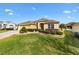 Charming one-story home featuring a well-manicured lawn and beautiful landscaping at 2197 Derringer Ave, The Villages, FL 32162