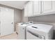 Bright laundry room with white cabinets and a newer washer and dryer at 2197 Derringer Ave, The Villages, FL 32162
