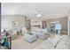 Open living room with tile flooring, a ceiling fan, and seamless flow to the kitchen and dining areas at 2197 Derringer Ave, The Villages, FL 32162