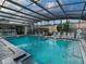 Beautiful, modern pool with chairs and tables on the side in an enclosed structure at 2714 Vindale Rd, Tavares, FL 32778