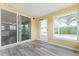 Bright sunroom with wood-look floors, slider to living room, and windows to let in natural light at 2714 Vindale Rd, Tavares, FL 32778