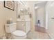 Bathroom featuring a toilet and single sink vanity; it is well-lit with tile flooring at 27536 Stoney Brook Dr, Leesburg, FL 34748