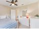 Bright bedroom featuring a bed, white furniture, ceiling fan, and an open doorway at 27536 Stoney Brook Dr, Leesburg, FL 34748