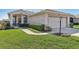 Charming single-story home featuring a well-manicured lawn and a two-car garage at 27536 Stoney Brook Dr, Leesburg, FL 34748