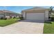 Exterior showing attached garage with wide driveway and maintained lawn in a 55+ community at 27536 Stoney Brook Dr, Leesburg, FL 34748
