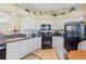 Fully equipped kitchen with white cabinets, dark countertops, and plenty of natural light at 27536 Stoney Brook Dr, Leesburg, FL 34748