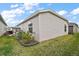 Home exterior shows lush green lawn, simple landscaping and light gray vinyl siding at 2866 Judah St, The Villages, FL 32163