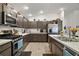 Modern kitchen featuring stainless steel appliances, stylish cabinetry, and durable laminate floors at 2866 Judah St, The Villages, FL 32163