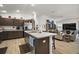 Modern kitchen flows into the living room; note stainless appliances, large island and laminate floors at 2866 Judah St, The Villages, FL 32163
