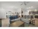 Open-concept living room with wood-style flooring, ceiling fan, and a view to the kitchen at 2866 Judah St, The Villages, FL 32163