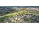 Aerial view of neighborhood with golf course and commercial development, showcasing community amenities at 2935 Cedar Grove Loop, The Villages, FL 32163