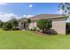 Expansive backyard showing a sunroom, a well-manicured lawn, and mature landscaping at 2935 Cedar Grove Loop, The Villages, FL 32163
