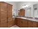 Bathroom with wood cabinets, granite countertops, and large mirror at 2935 Cedar Grove Loop, The Villages, FL 32163