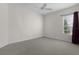 Neutral bedroom with plush carpet, ceiling fan, and a large window at 2935 Cedar Grove Loop, The Villages, FL 32163