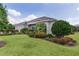 Well-kept single-story home with manicured lawn, detailed landscaping, and three-car attached garage at 2935 Cedar Grove Loop, The Villages, FL 32163