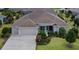 Well-maintained single-story home featuring an attached three-car garage, manicured lawn, and mature landscaping at 2935 Cedar Grove Loop, The Villages, FL 32163