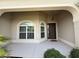 Inviting front porch with a charming entryway and an arched window allowing natural light at 2935 Cedar Grove Loop, The Villages, FL 32163