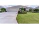 Beautifully landscaped single-story home with manicured lawn and a two-car garage at 2935 Cedar Grove Loop, The Villages, FL 32163