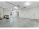 Spacious garage with high ceilings, neutral colors, and multiple doors for easy access and storage at 2935 Cedar Grove Loop, The Villages, FL 32163