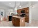 Modern kitchen featuring center island, tile flooring, and breakfast bar overlooking dining area at 2935 Cedar Grove Loop, The Villages, FL 32163