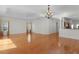Inviting living room with hardwood floors, tray ceiling, windows, and an open transition to the kitchen at 2935 Cedar Grove Loop, The Villages, FL 32163