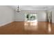 Spacious living room with hardwood floors, chandelier, and sliding glass doors to a screened lanai at 2935 Cedar Grove Loop, The Villages, FL 32163
