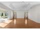 Bright living room with hardwood floors, tray ceilings, and large windows with plantation shutters at 2935 Cedar Grove Loop, The Villages, FL 32163