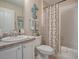 Well-appointed bathroom featuring a vanity, toilet, and a bathtub with a patterned shower curtain at 3067 Southern Trce, The Villages, FL 32162