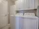 Well-equipped laundry room featuring a washer, dryer, and ample cabinet storage for convenience at 3067 Southern Trce, The Villages, FL 32162