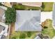 Birds eye view of home with a large roof, well manicured yard, mature trees, and an extended driveway at 3233 Belcherry Loop, The Villages, FL 32163