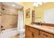 Bathroom with neutral tile, a shower with a tub, and a vanity with a granite countertop at 3233 Belcherry Loop, The Villages, FL 32163