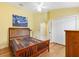 Bedroom featuring hardwood floors, yellow walls, closet doors, and a painting at 3233 Belcherry Loop, The Villages, FL 32163