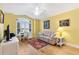 Bedroom with hardwood floors, yellow walls, a ceiling fan, and a large window with shutters at 3233 Belcherry Loop, The Villages, FL 32163