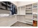A spacious walk-in closet featuring custom shelving, hanging racks, and wood-look laminate flooring at 3233 Belcherry Loop, The Villages, FL 32163