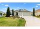 Charming single-story home featuring a well-manicured lawn, tasteful landscaping, and a spacious three-car garage at 3233 Belcherry Loop, The Villages, FL 32163