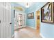 Bright foyer featuring a decorative front door, tile flooring, and soft blue walls at 3233 Belcherry Loop, The Villages, FL 32163