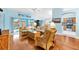 Relaxing living room featuring hardwood floors, comfortable rattan furniture, and a view into the kitchen at 3233 Belcherry Loop, The Villages, FL 32163