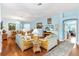 Bright living room featuring hardwood floors, rattan furniture, and an inviting atmosphere at 3233 Belcherry Loop, The Villages, FL 32163
